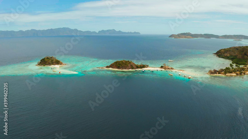 aerial seascape bay with tropical island and sand beach  turquoise water and coral reef. Bulog Dos  Philippines  Palawan. tourist boats on coast tropical island.