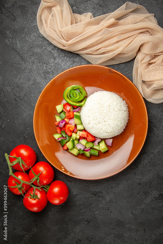 Above view of vegan dinner with rice and different types of vegetables on dark table Above view of vegan dinner with rice and different types of vegetables on dark table