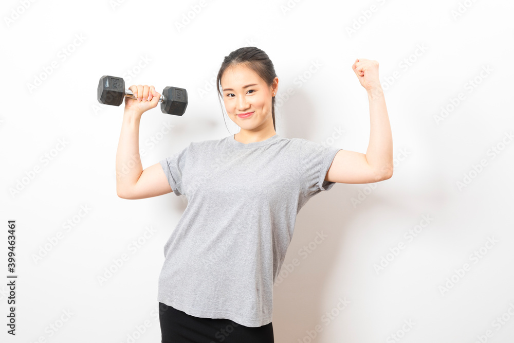Beautiful young Asian woman lifting dumbbells smiling and energetic isolated over white background. Healthy lifestyle. Beautiful young Asian woman lifting dumbbells smiling and energetic isolated over white background. Healthy lifestyle.