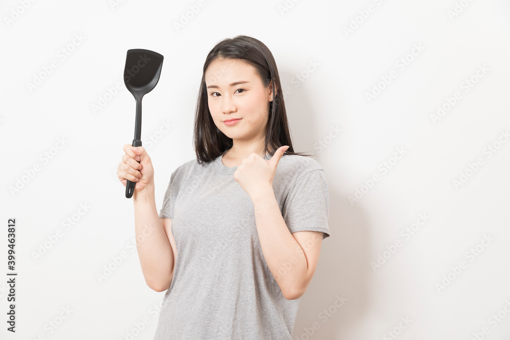 Asian woman holding ladle ready for cooking isolated on white background. Asian woman holding ladle ready for cooking isolated on white background.