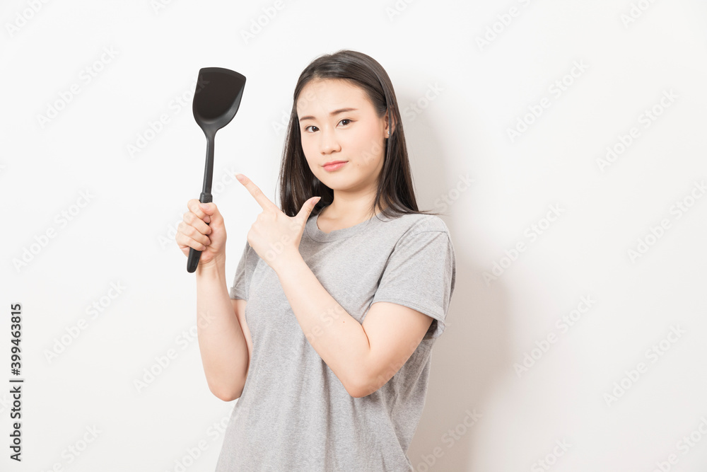 Asian woman holding ladle ready for cooking isolated on white background. Asian woman holding ladle ready for cooking isolated on white background.