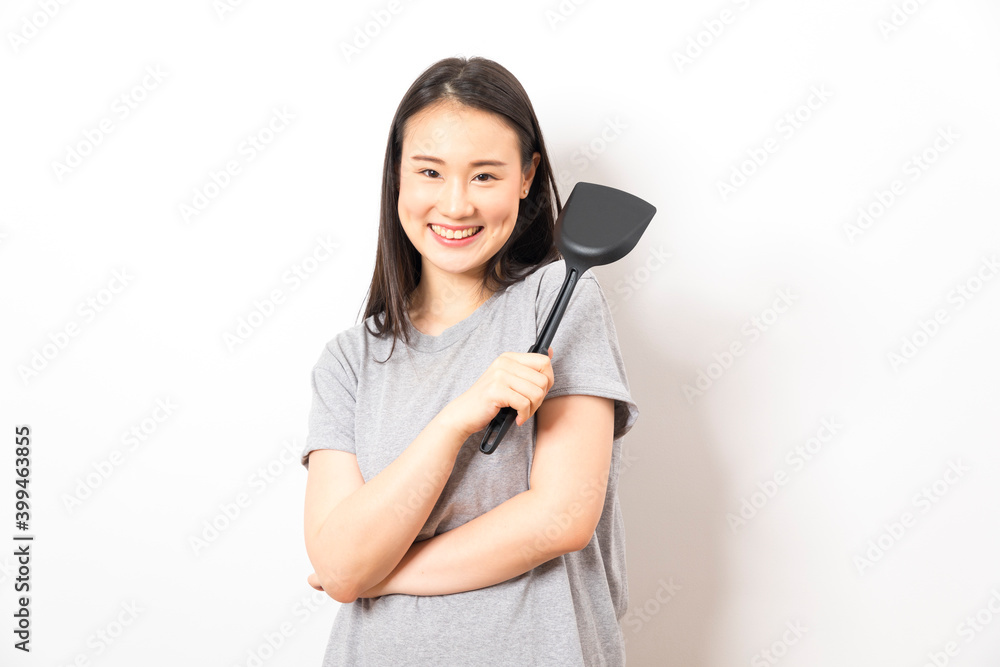 Asian woman holding ladle ready for cooking isolated on white background. Asian woman holding ladle ready for cooking isolated on white background.