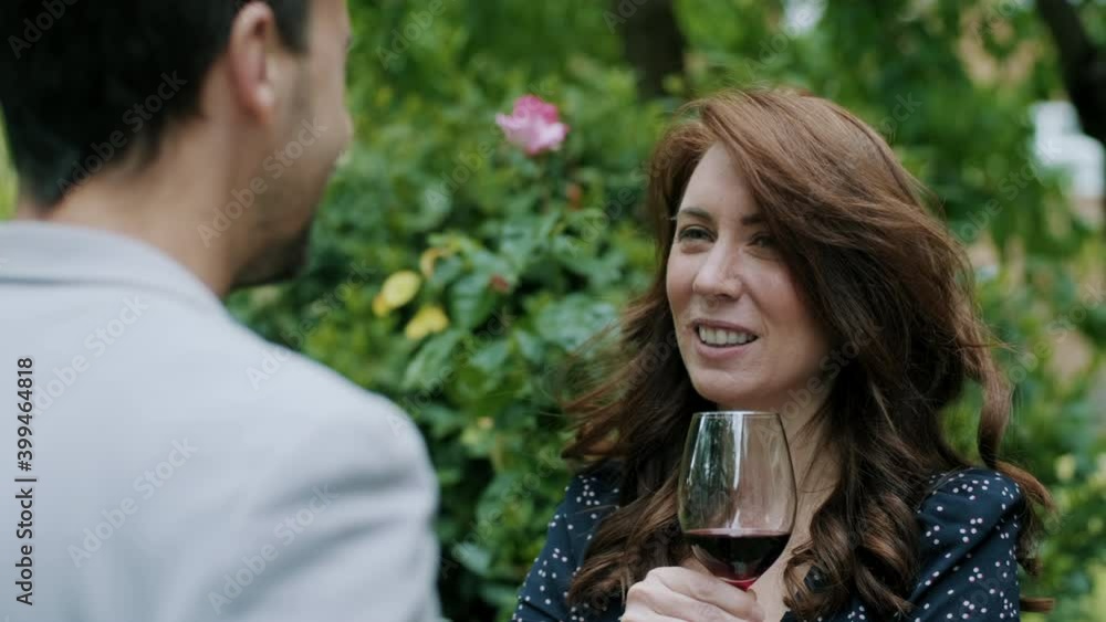 Woman talking with a glass of red wine in her hands and smiling Woman talking with a glass of red wine in her hands and smiling