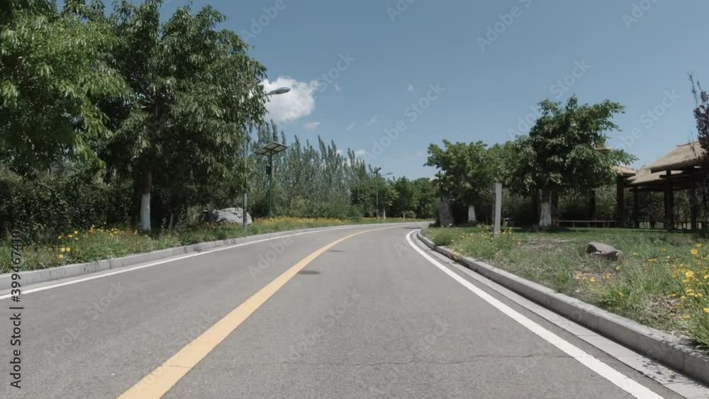 Biking on bike path in beautiful park in sunny weather. No people in national park bike road in peaceful recreational activity area. Biking on bike path in beautiful park in sunny weather. No people in national park bike road in peaceful recreational activity area.
