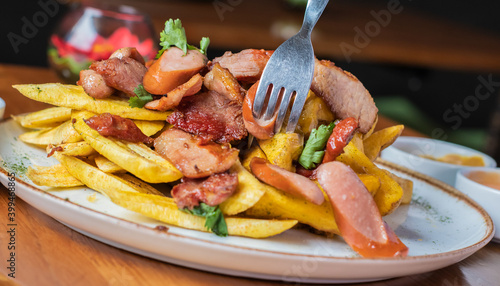 Obraz na płótnie Salchipapa Frankfurt con plátano frito y papas fritas.