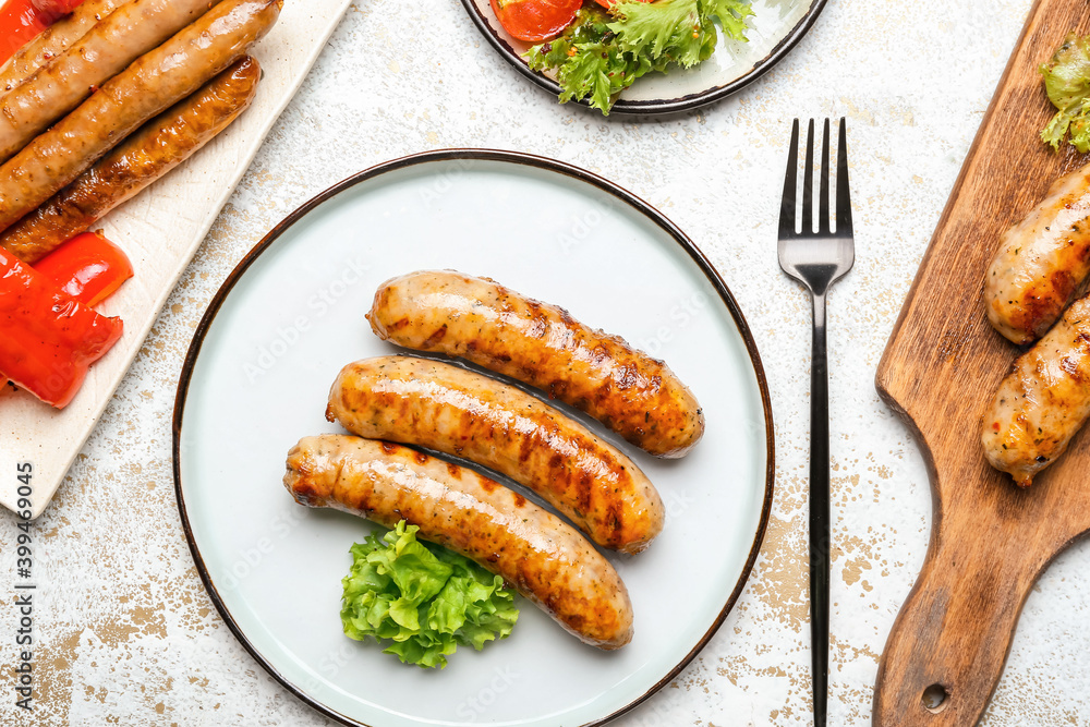Plate with delicious grilled sausages and vegetables on wooden table Plate with delicious grilled sausages and vegetables on wooden table