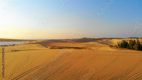 Aerial view of Bau Trang lake  raw of automobiles with blue sky in desert  beautiful landscape of white sand dunes   the popular tourist attraction place in Mui Ne  Vietnam.