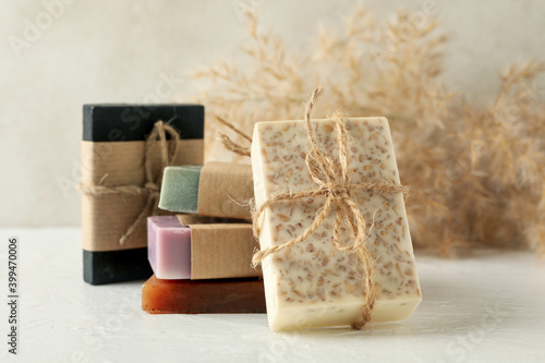 Reed branches and natural soap on white table