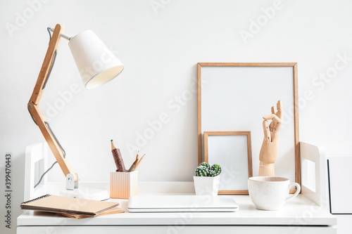 Wooden hand with laptop and lamp on table in interior of room