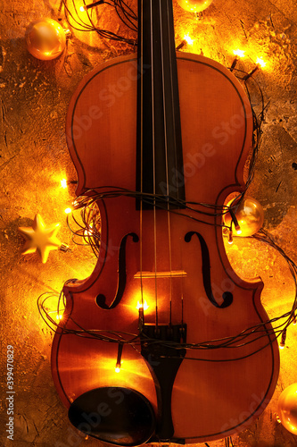 Violin with Christmas lights and decor on grunge background