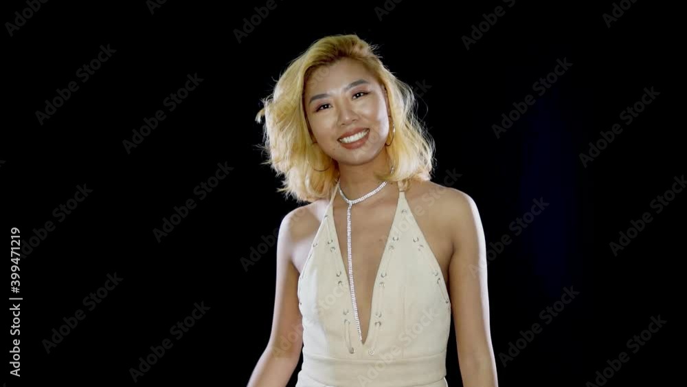 Shy blonde Asian girl posing and playing with her hair. Glamorous smiling Chinese woman with dyed hair flirting and ready to go clubbing and party. Shy blonde Asian girl posing and playing with her hair. Glamorous smiling Chinese woman with dyed hair flirting and ready to go clubbing and party.