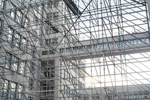 Extensive scaffolding providing platforms for work in progress on a tall building under construction with scaffolds.