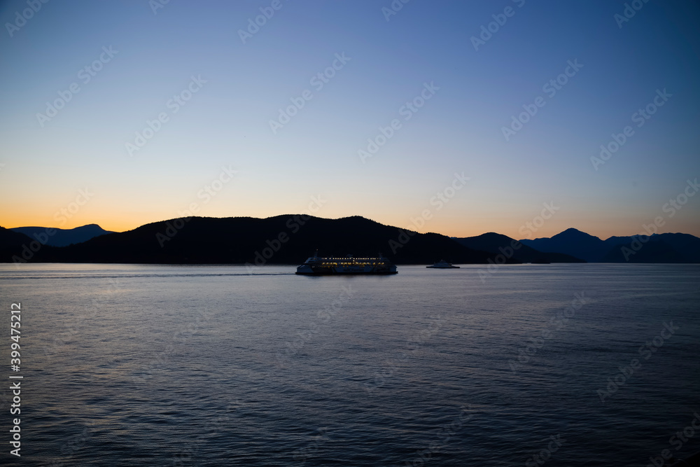 two ferries passing on Howe Sound with Bowen Island in the distance at sunset or twilight