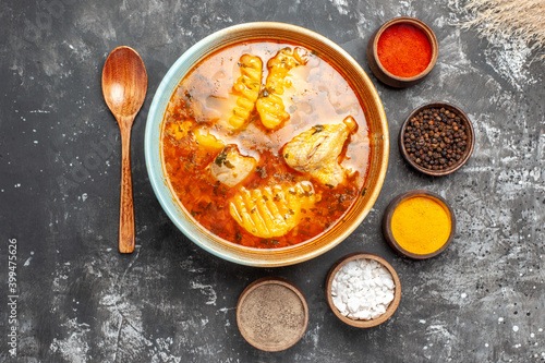 Overhead view of chicken dish spices set and spoon on dark background photo