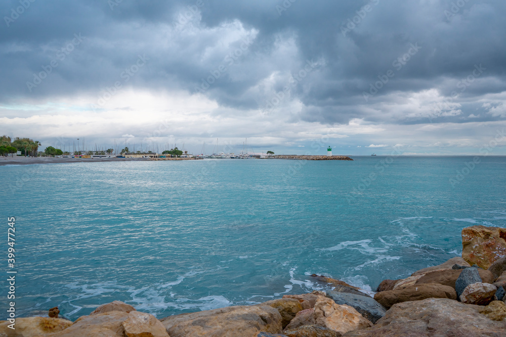 Lighthouse on the beautiful azure sea under the cloudy sky. Panoramic sea view