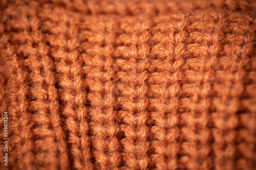 Orange wool scarf background texture. Macro photo with selective focus.