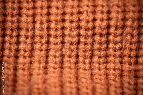 Orange wool scarf background texture. Macro photo with selective focus.