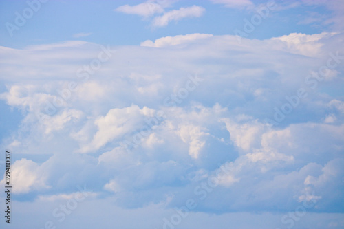 Cumulus and cirrus clouds in the blue sky. Atmospheric phenomenon, weather, summer.