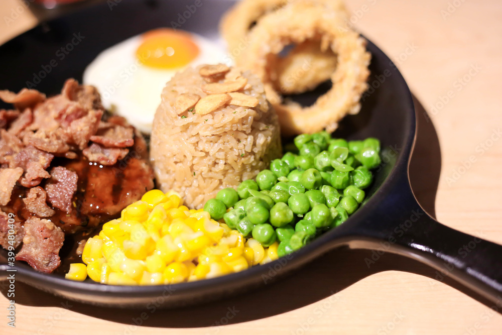 Griled chicken breast steak with rice and onions,corns,Green peas vegetable,soft focus Griled chicken breast steak with rice and onions,corns,Green peas vegetable,soft focus