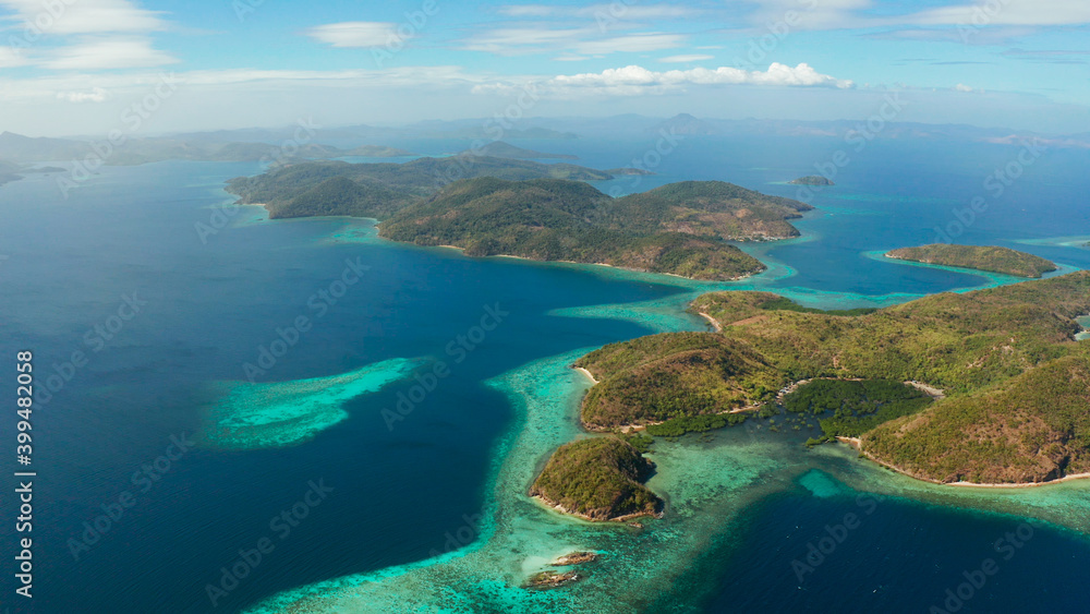 aerial view tropical islands with blue lagoons, coral reef and sandy beach. Palawan, Philippines. Islands of the Malayan archipelago with turquoise lagoons.