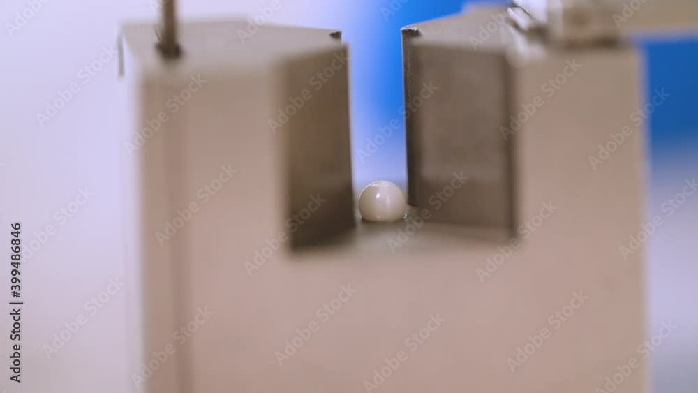 Close Up of Placing Tiny Ball into a Hole with Tweezers Close Up of Placing Tiny Ball into a Hole with Tweezers