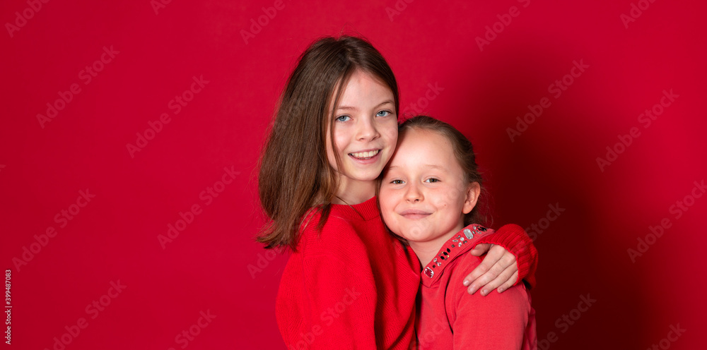 best girlfriends wearing red clothes posing and standing in front of red background best girlfriends wearing red clothes posing and standing in front of red background