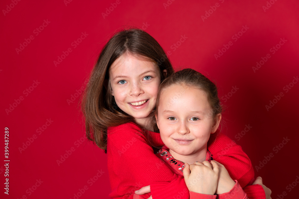best girlfriends wearing red clothes posing and standing in front of red background best girlfriends wearing red clothes posing and standing in front of red background