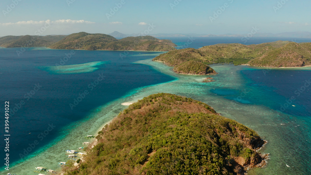Tropical islands with blue lagoons, coral reef and sandy beach, aerial view. Palawan, Philippines. Islands of the Malayan archipelago with turquoise lagoons.