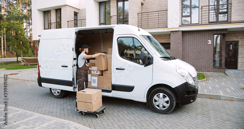 Fotografía Caucasian handsome young delivery man post office worker delivering home many boxes