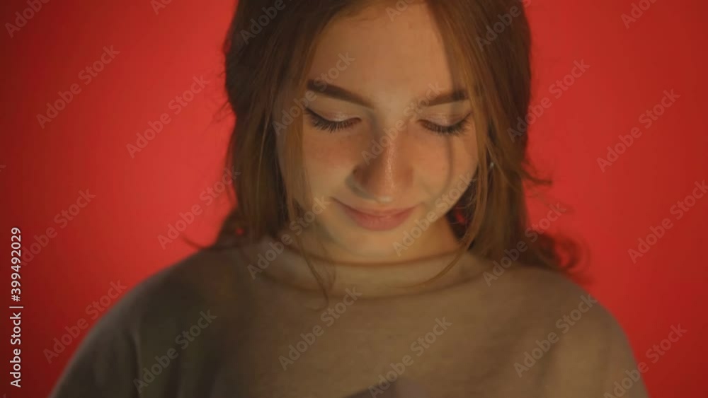 Young woman opens a box with a gift and smiles Young woman opens a box with a gift and smiles