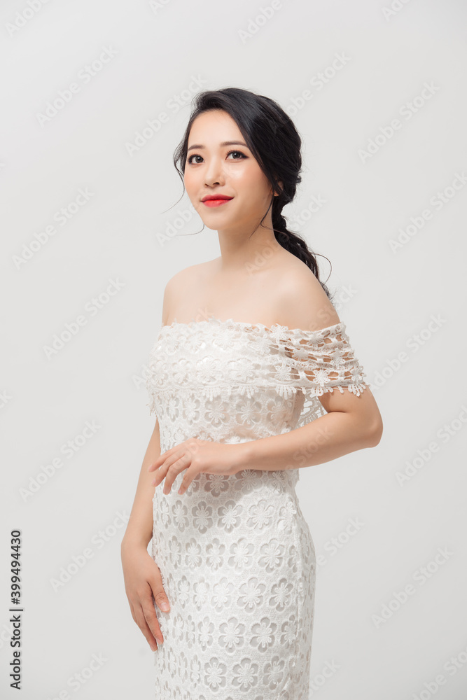 Attractive young Asian lady wearing white skinny dress isolated over white background. Attractive young Asian lady wearing white skinny dress isolated over white background.