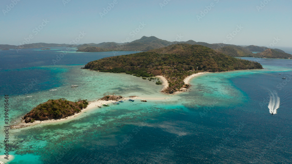 aerial seascape bay with tropical island and sand beach, turquoise water and coral reef. Bulog Dos, Philippines, Palawan. tourist boats on coast tropical island.