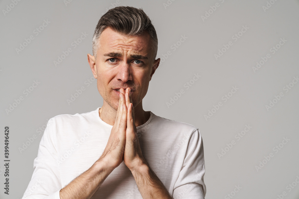 Worried man begging and praying with hands together Worried man begging and praying with hands together