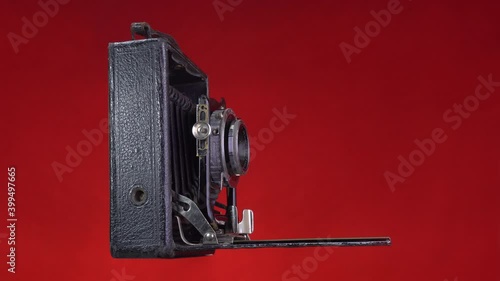 Timelapse  old antique photo camera shooting. Isolated on red background. Vintage object. photo