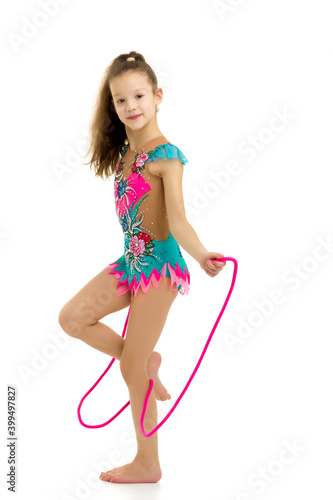 A girl gymnast performs exercises with a skipping rope. © lotosfoto