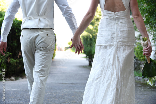 Newlyweds walking hand in hand outdoors, seen from the background. Love. wedding. Valentine's day. Engagement 