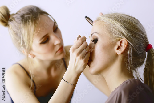 professional make-up in the beauty salon / master makes a professional fresh summer make-up of a beautiful model in the salon