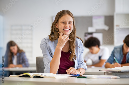 Happy smiling student girl studying in classroom photo