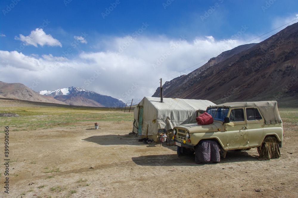 Kyrgyz nomad camp with tent and car along the Pamir Highway in high-altitude summer pasture between Ak Baital pass and Karakul lake in Murghab district, Gorno-Badakshan, Tajikistan Kyrgyz nomad camp with tent and car along the Pamir Highway in high-altitude summer pasture between Ak Baital pass and Karakul lake in Murghab district, Gorno-Badakshan, Tajikistan