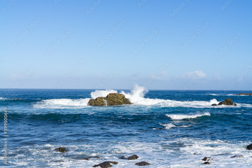 The rough Atlantic Ocean near Tenerife, Spain, strong waves break on the rocks in the water