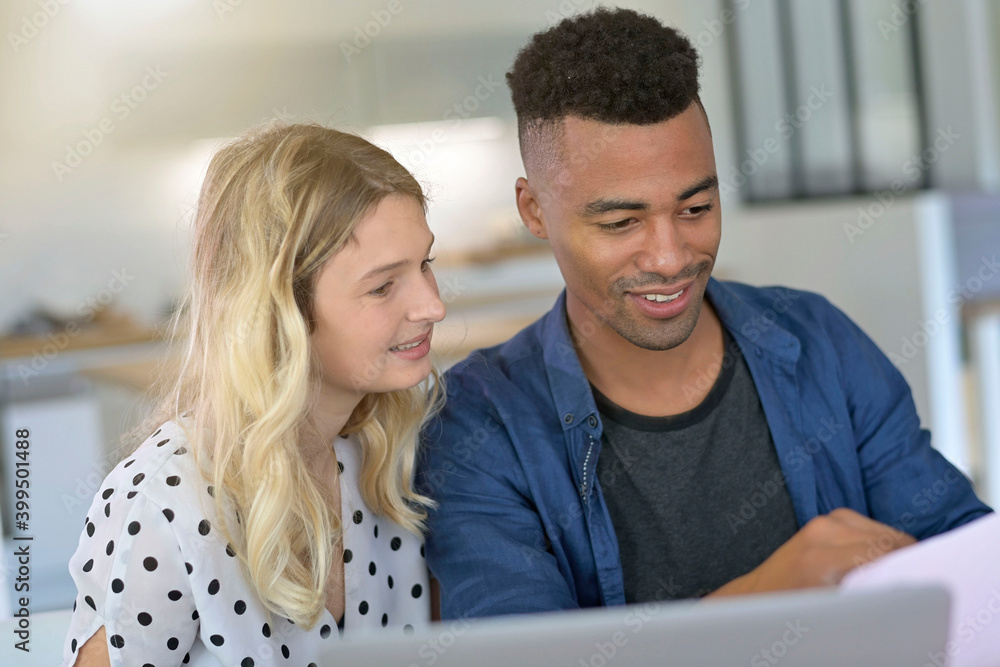 Mixed-raced couple connected on laptop at home Mixed-raced couple connected on laptop at home