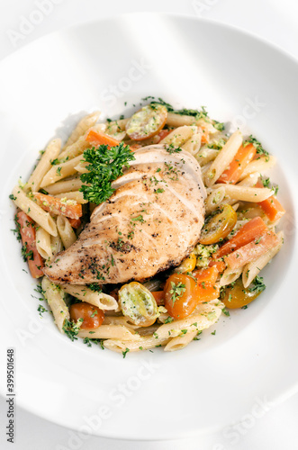 fried chicken breast with penne and saute vegetables pasta dish