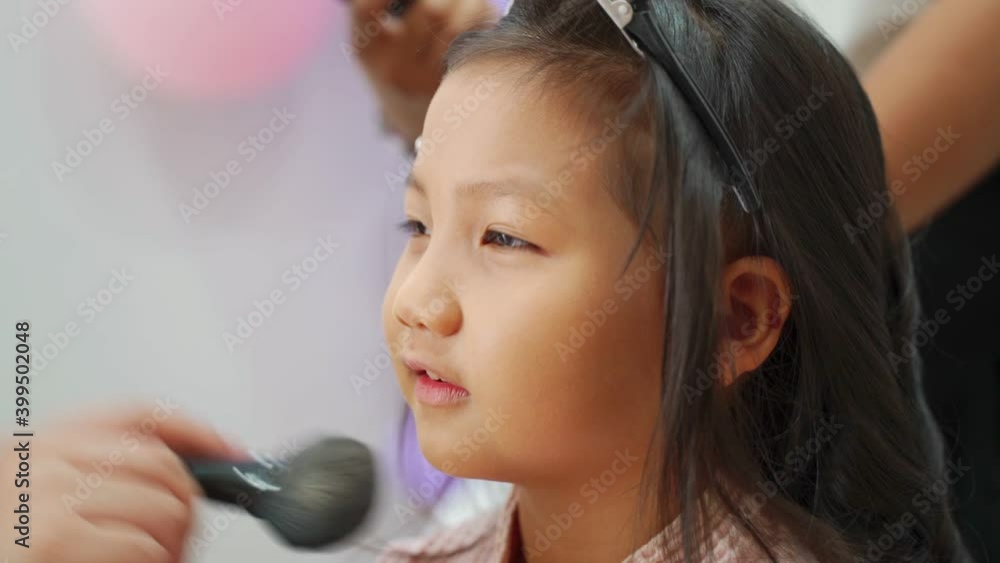 happy asian girl having face makeup by artist. confident kid feels satisfy when beautiful. happy asian girl having face makeup by artist. confident kid feels satisfy when beautiful.
