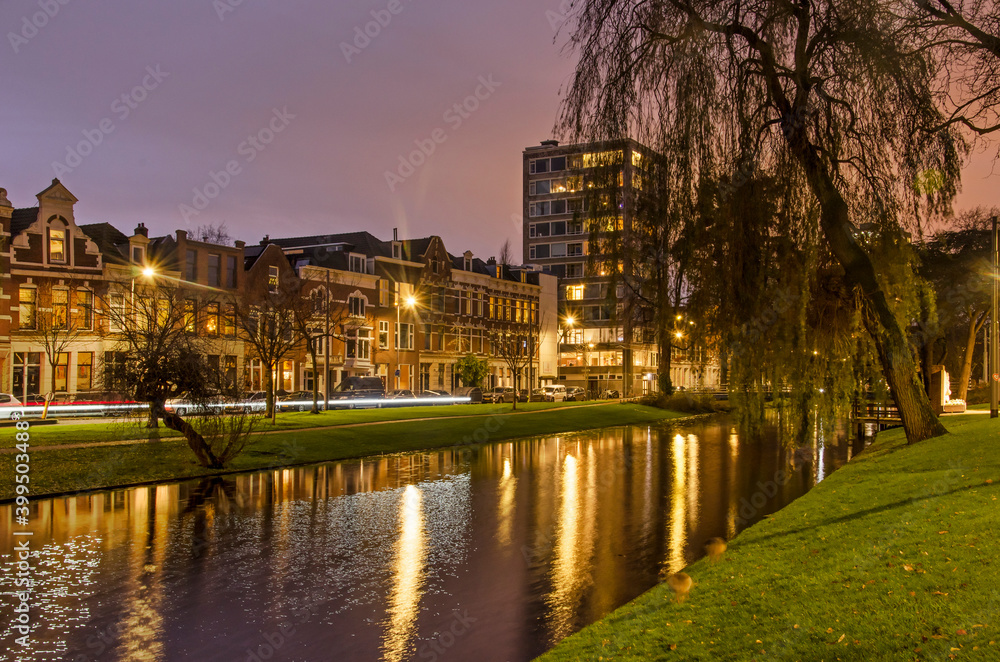 Rotterdam, The Netherlands, December 13, 2020: historic houses and a more recent apartment tower along Noordsingel canal during the blue hour