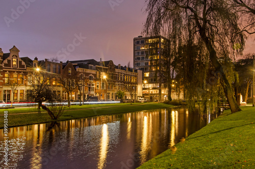 Rotterdam, The Netherlands, December 13, 2020: historic houses and a more recent apartment tower along Noordsingel canal during the blue hour