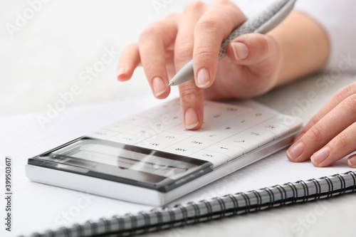 Female accountant with calculator working in office, closeup