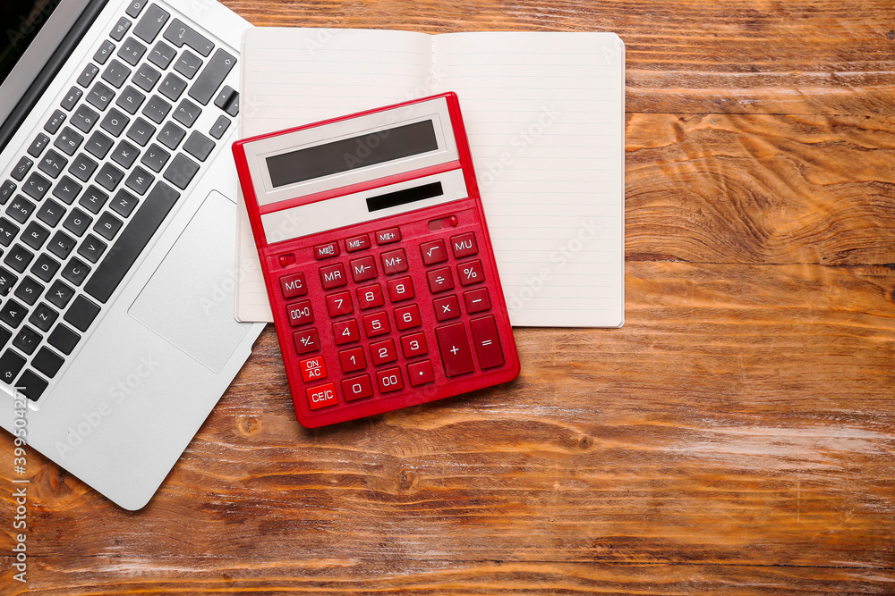 Modern calculator, laptop and notebook on wooden background Modern calculator, laptop and notebook on wooden background
