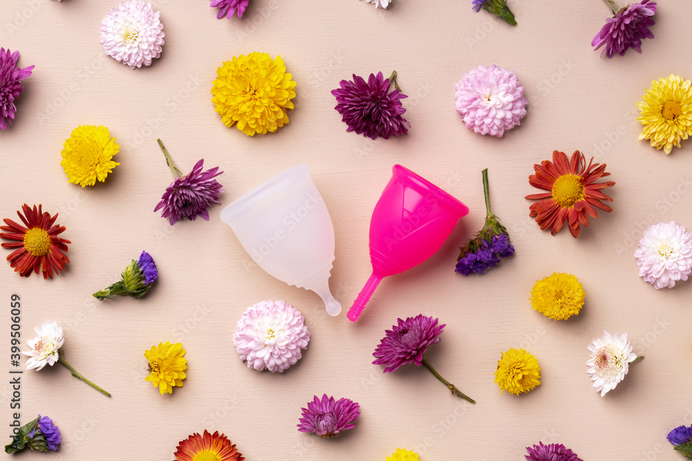 Menstrual cup on floral pattern background top view Menstrual cup on floral pattern background top view