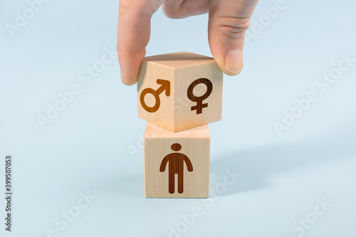 selection or changing gender concept. hand turns cube with the male and female icons over the cube with human icon