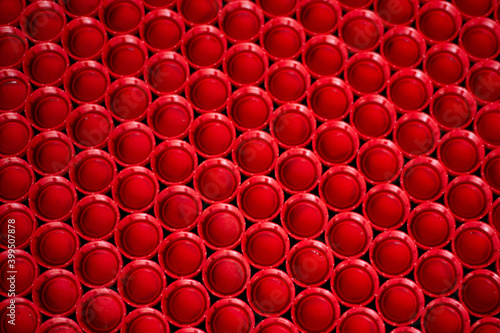recycling plastic concept. red abstract background of plastic caps from a bottle, top view, short focus